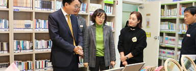 LH5단지 프로그램 성과나눔 전시회 나주시장이 테이블에 전시된 작품들을 바라보며 관계자에게 설명을 듣고 잇는 모습