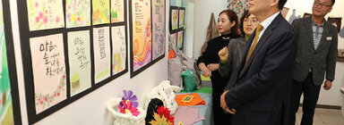 LH5단지 프로그램 성과나눔 전시회 나주시장이 벽에 걸린 작품들을 바라보고 있는 모습
