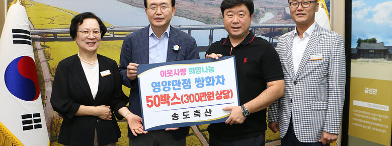 송동축산 후원물품 기탁식 나주시장과 송도축산 대표 및 시청 간부공무원이 판넬을 들고 기념촬영을 하고 있는 모습