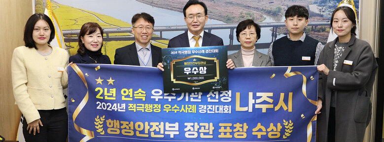 적극행정 우수사례 경진대회 행안부 장관 표창 수상 나주시장과 담당부석 직원들이 플래카드를 펼치고 기념촬영을 하고 있는 모습