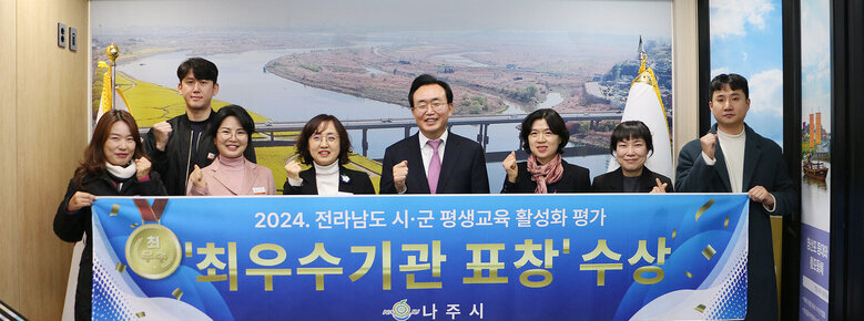 전라남도 시군 평생교육 활성화 평가 최우수기관 표창 나주시장과 담당부서 직원들이 플래카드를 펼치고 기념촬영 하는 모습