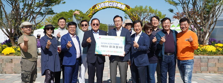  2024나주영산강 축제 | 나주시고향사랑기부제 2년 연속 최고액 기부동참 석창건설 이재철 회장 내 고향 나주시를 응원합니다! 라고 적힌 팻말을 들고 있는  이재철 회장과 윤병태 시장 뒤로 11명의 직원일동이 손하트를 하고 있다