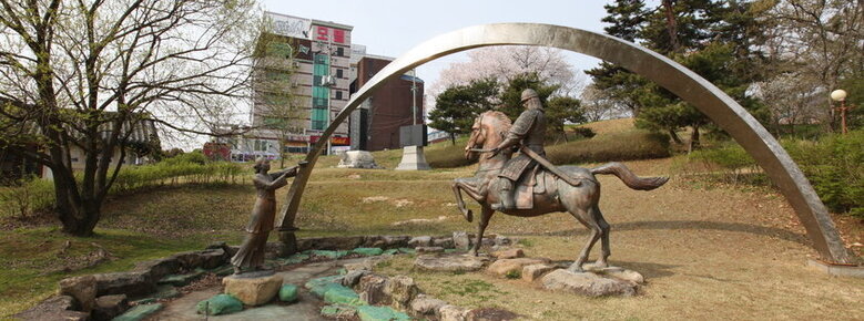 완사천에 전경을 찍은 사진. 잔디밭 사이로 말을탄 장군복을 입은 동상과 여인의 동상이 보이며 완사천에 물이 말라 있음.