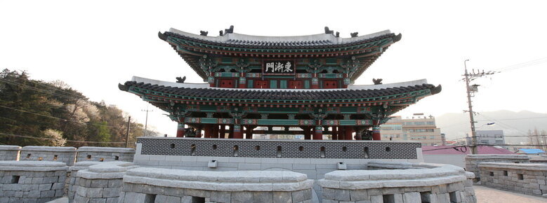 동점문 정면을 찍은 사진. 가지련한 돌로 성벽이 쌓여 있고 그 뒤로 2층짜리 기와가 있고 동점문이라고 한자로 쓰여진 현판걸려 있음.