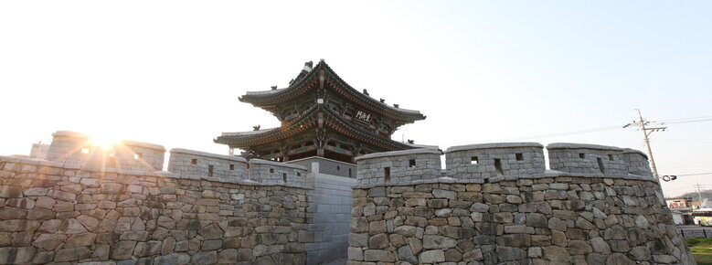 동점문 측면을 찍은 사진. 성벽이 보이고 그 뒤로 2층짜리 기와에 동점문이라는 현판이 걸려 있음.