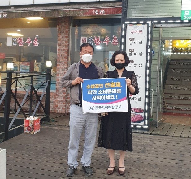 선결제 캠페인 안내판을들고 가게정문앞에서 촬영한 사진