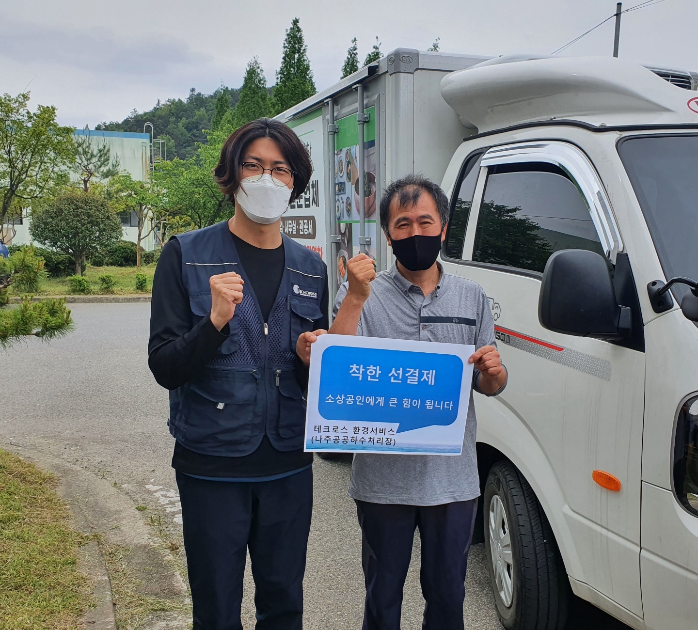 선결제 캠페인 안내판을들고 야외에서 촬영한 사진